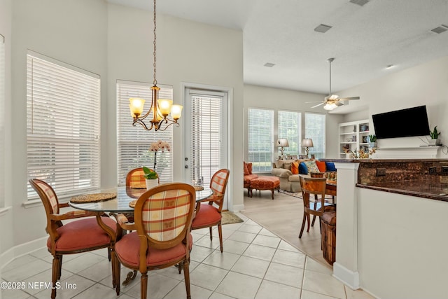 dining space featuring light tile patterned floors, visible vents, baseboards, a textured ceiling, and ceiling fan with notable chandelier