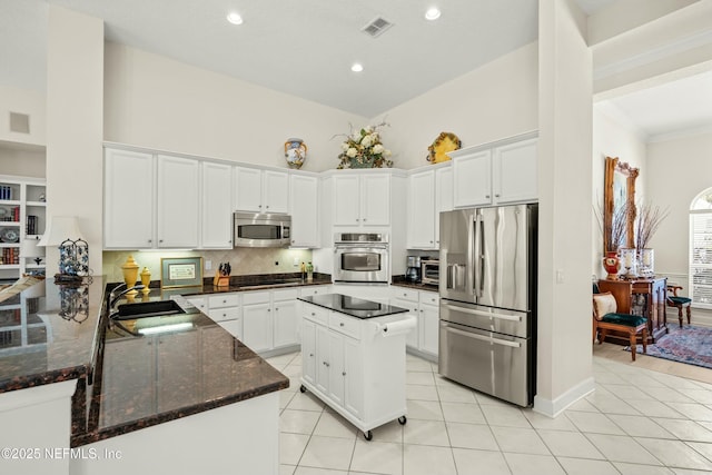 kitchen featuring light tile patterned floors, appliances with stainless steel finishes, and white cabinetry