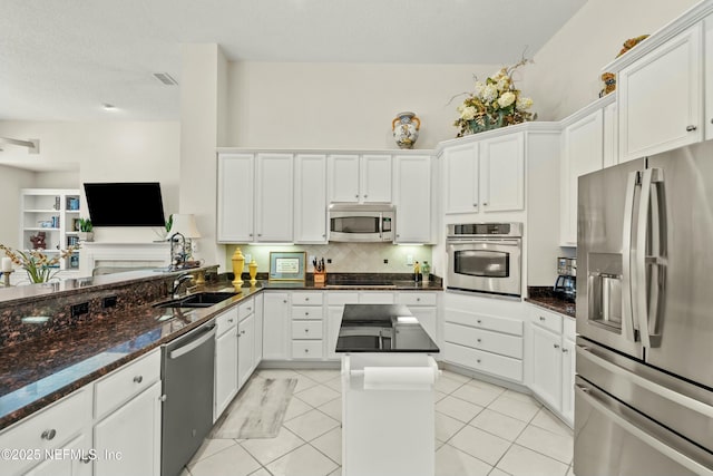 kitchen featuring white cabinetry, light tile patterned floors, appliances with stainless steel finishes, and a sink