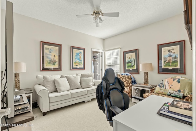 office space with light colored carpet, ceiling fan, and a textured ceiling