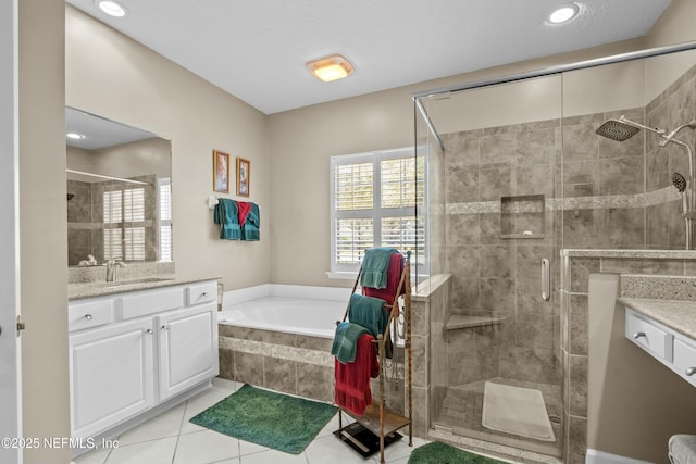 bathroom featuring a bath, tile patterned flooring, a stall shower, and vanity