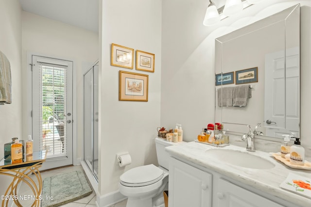 bathroom with vanity, tile patterned floors, toilet, and a stall shower