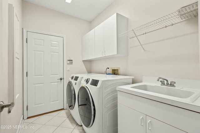 laundry area featuring washer and dryer, light tile patterned flooring, cabinet space, and a sink