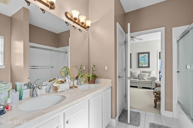 ensuite bathroom featuring a sink, a shower with shower door, double vanity, and tile patterned flooring