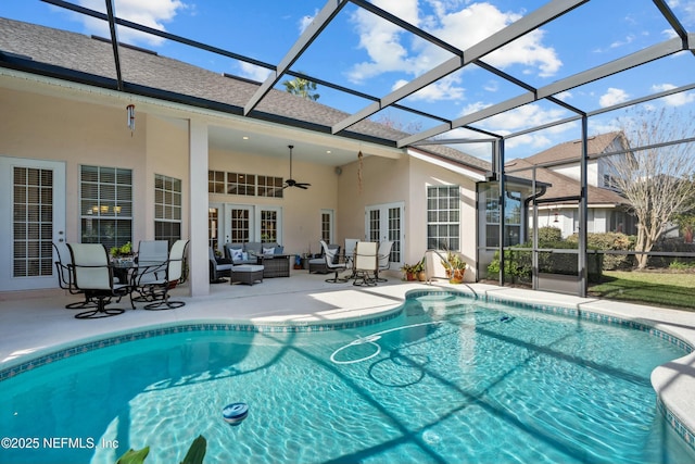 pool with a ceiling fan, an outdoor living space, a patio, french doors, and a lanai