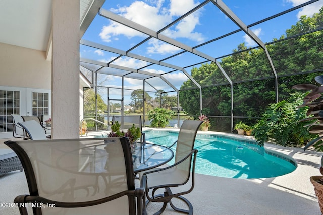 pool with a patio area, outdoor dining space, and glass enclosure