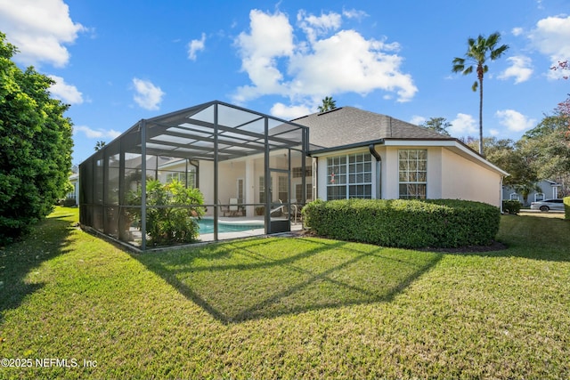 rear view of house with stucco siding, a yard, a shingled roof, an outdoor pool, and a lanai