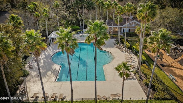 pool with a patio, fence, and a hot tub