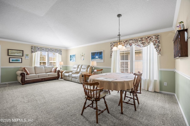 dining space featuring ornamental molding, carpet, a textured ceiling, and baseboards