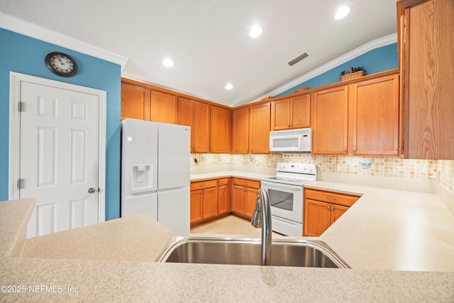 kitchen featuring lofted ceiling, white appliances, light countertops, and a sink