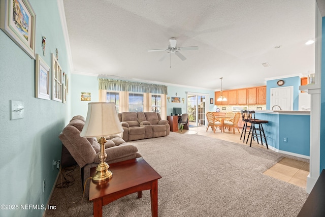 tiled living area with carpet floors, crown molding, a ceiling fan, a textured ceiling, and baseboards