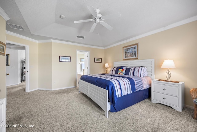 carpeted bedroom featuring baseboards, visible vents, a raised ceiling, and crown molding