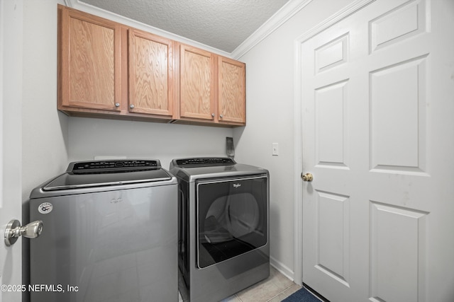 laundry area featuring light tile patterned floors, cabinet space, ornamental molding, a textured ceiling, and independent washer and dryer