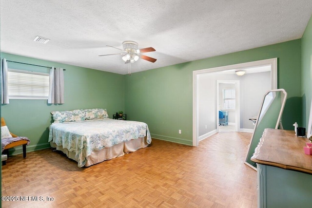 bedroom with a ceiling fan, visible vents, a textured ceiling, and baseboards