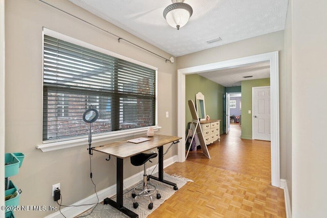 office space with a textured ceiling and baseboards