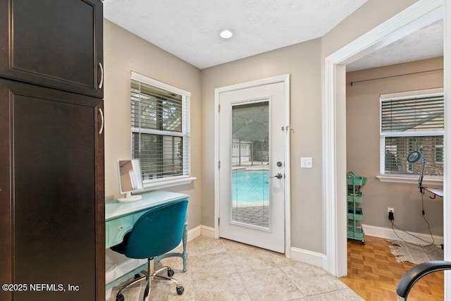 office space featuring a textured ceiling and baseboards