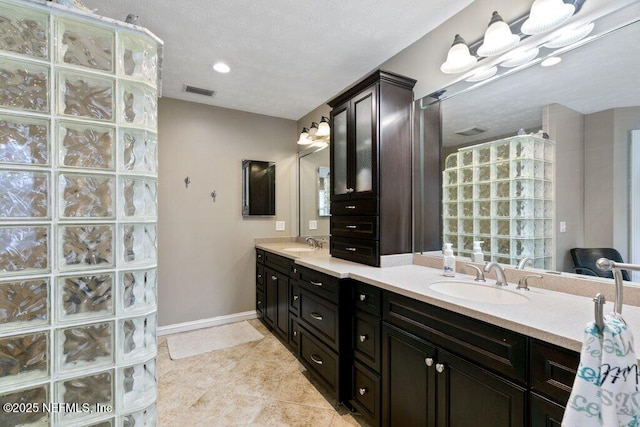 full bathroom with double vanity, tile patterned flooring, baseboards, and a sink