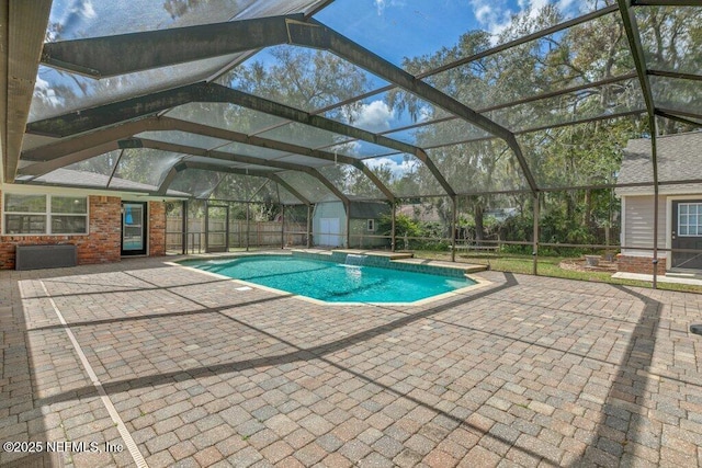 pool featuring an outbuilding, a storage unit, glass enclosure, a patio area, and fence