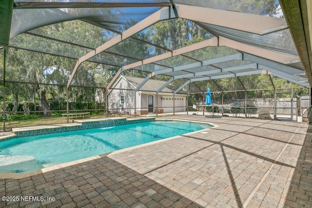 view of swimming pool featuring a patio area, glass enclosure, and a fenced in pool