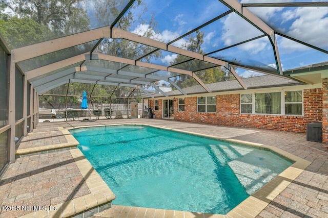 pool with a patio and glass enclosure