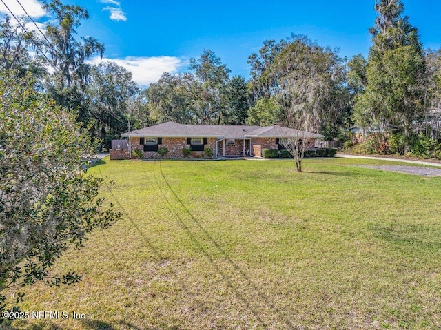 ranch-style home with a front yard and brick siding