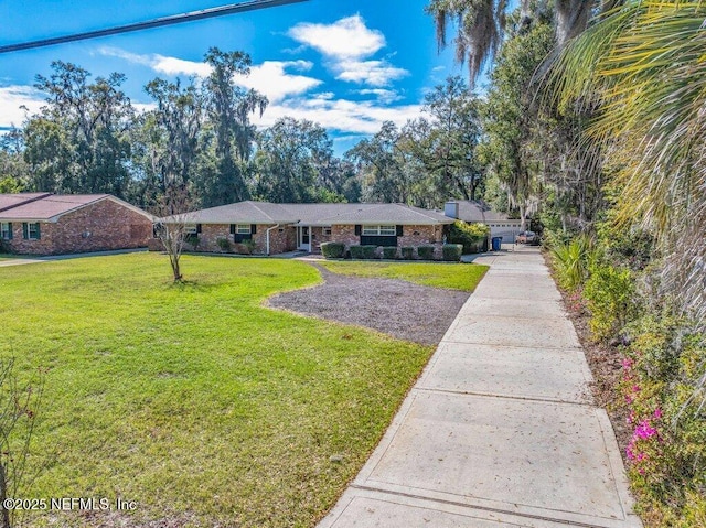 ranch-style house with a front lawn, concrete driveway, and brick siding