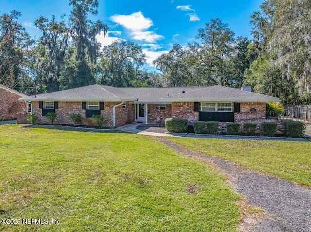 single story home with brick siding, a chimney, and a front lawn