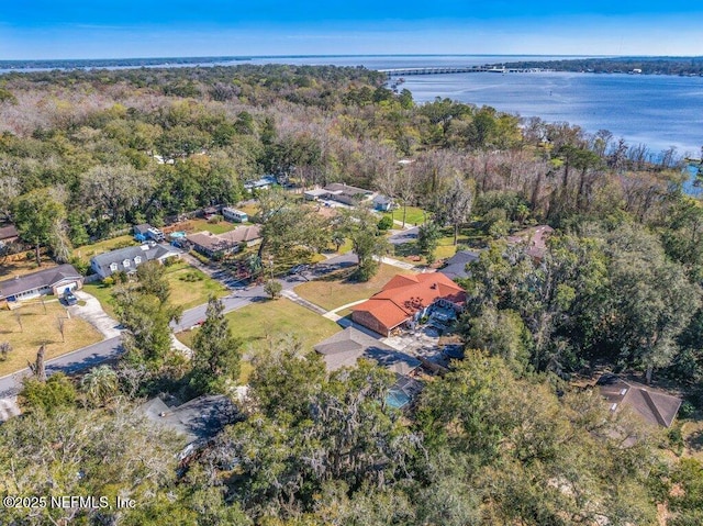 drone / aerial view with a water view and a wooded view