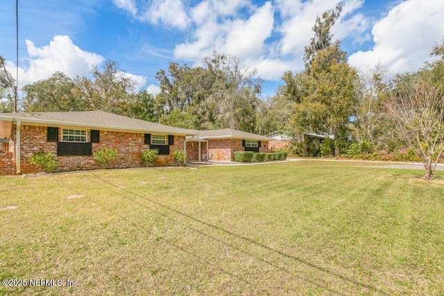 single story home with brick siding and a front yard