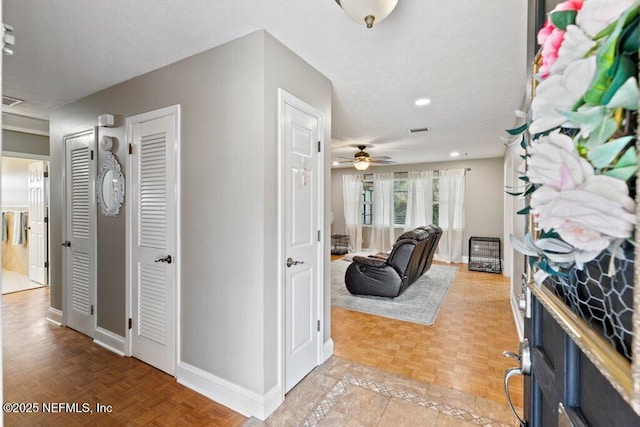 entrance foyer featuring visible vents, ceiling fan, a textured ceiling, and baseboards