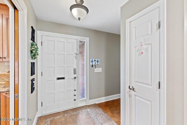 foyer entrance featuring baseboards