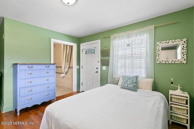 bedroom featuring dark wood-type flooring and a textured ceiling