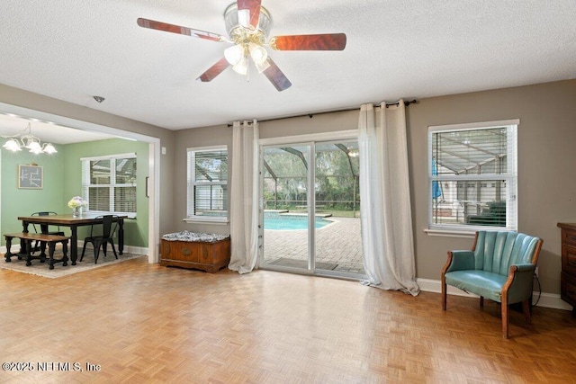 interior space with a textured ceiling, a ceiling fan, and baseboards