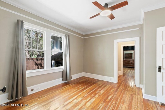 empty room featuring light wood-style flooring, ornamental molding, ceiling fan, and baseboards