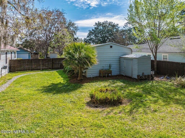 view of yard featuring fence private yard, an outdoor structure, and a storage shed