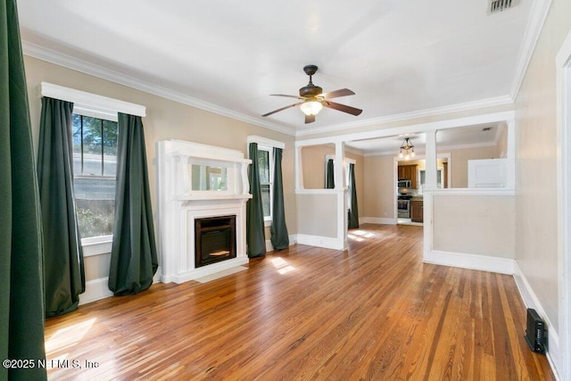 unfurnished living room featuring baseboards, ornamental molding, a fireplace, and light wood-style floors