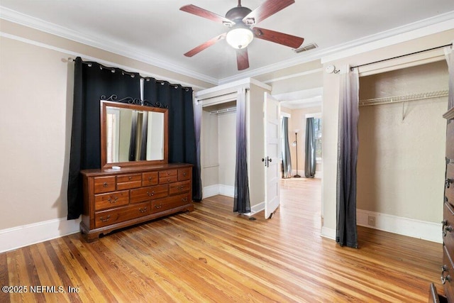 bedroom featuring light wood-type flooring, visible vents, crown molding, and baseboards