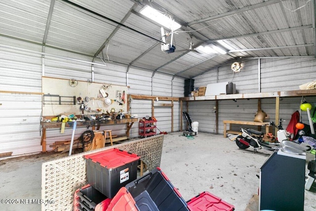 garage featuring a workshop area, metal wall, and a garage door opener