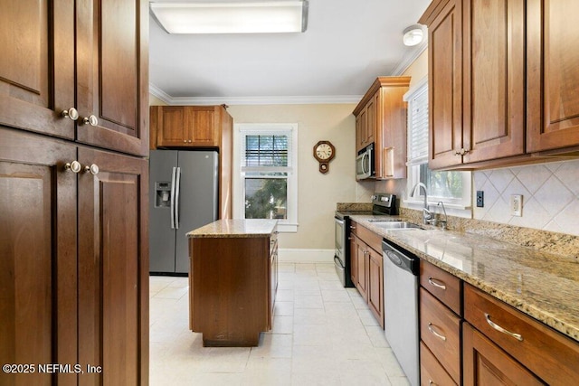 kitchen with stainless steel appliances, crown molding, a sink, and a kitchen island