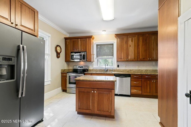 kitchen with decorative backsplash, ornamental molding, light stone countertops, stainless steel appliances, and a sink