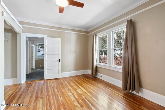 unfurnished room with light wood-type flooring, baseboards, and crown molding