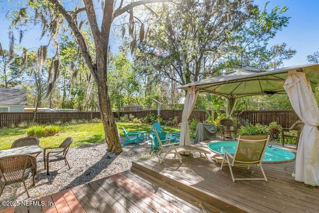 wooden terrace featuring a fenced backyard and a gazebo