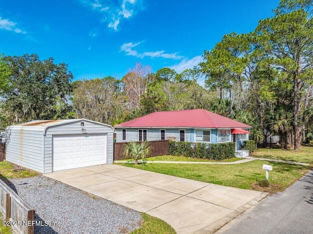 view of front of home featuring an outbuilding, a front yard, fence, and a detached garage