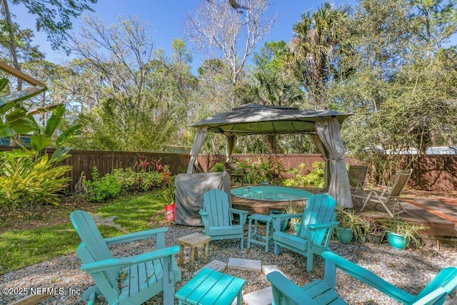 view of patio featuring a gazebo, a fenced backyard, area for grilling, and outdoor dining space