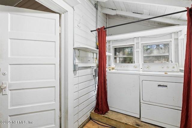 washroom with wooden ceiling, laundry area, wood walls, light wood-type flooring, and washing machine and clothes dryer