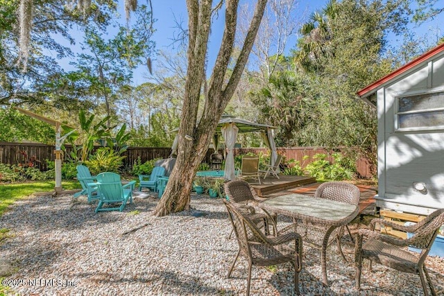 view of patio with a wooden deck, a fenced backyard, and a gazebo