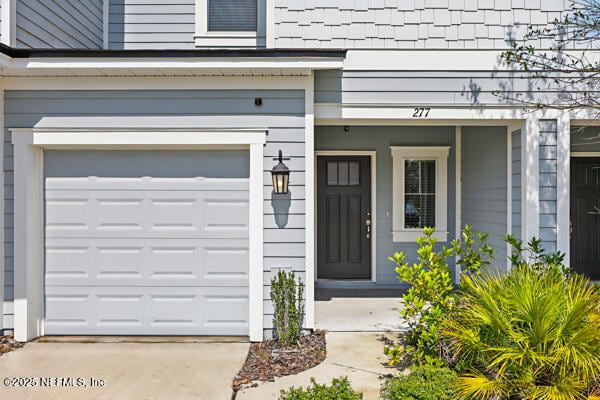 view of exterior entry featuring concrete driveway