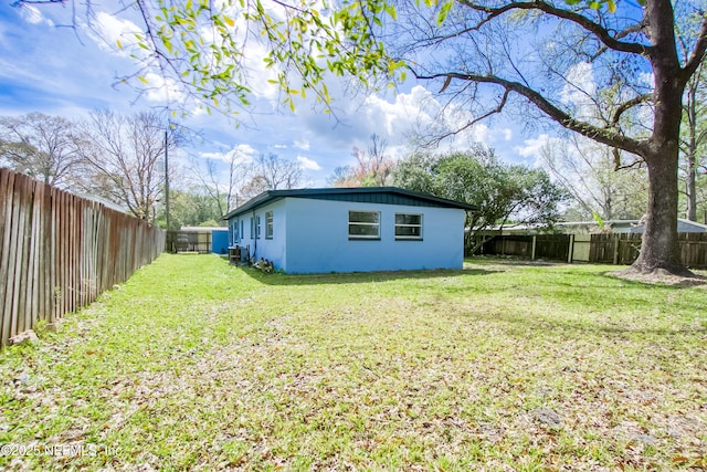 view of yard featuring a fenced backyard and central AC