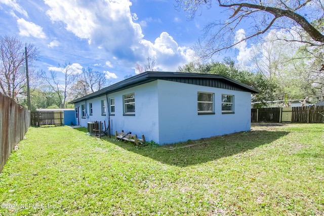 view of property exterior featuring a fenced backyard, a lawn, cooling unit, and stucco siding