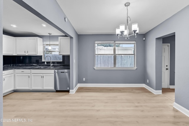 kitchen featuring a sink, dark countertops, white cabinets, and dishwasher